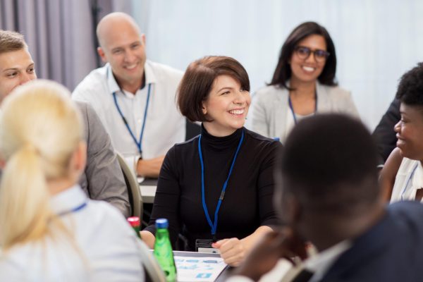 business and education concept - group of happy people talking at international conference
